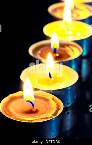 number of hot yellow candles in the dark Stock Photo