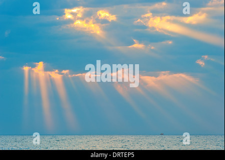 rays of the sun breaking through the clouds over the sea Stock Photo