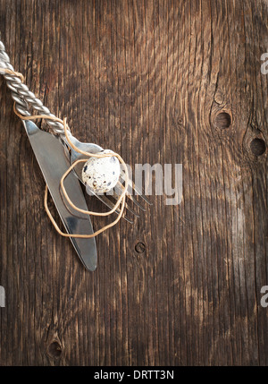 Easter table setting with quail eggs and cutlery on old wooden table Stock Photo
