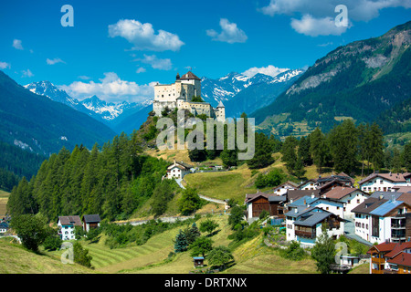 Tarasp Castle surrounded by larch and pine forest under cerulean sky in the Lower Engadine Valley, Switzerland Stock Photo