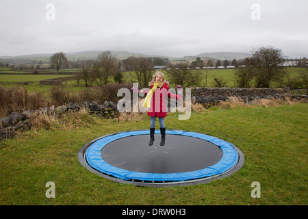 young blonde girl bounces on a trampoline in the English countryside Stock Photo - Alamy