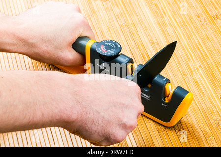 adjustable manual knife sharpener on wooden background Stock Photo