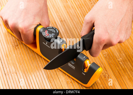 adjustable manual knife sharpener on wooden background Stock Photo