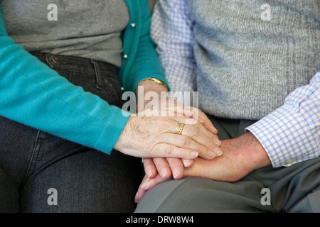 Holding hands, comforting senior woman's hand comforting a man. Landscape. Stock Photo
