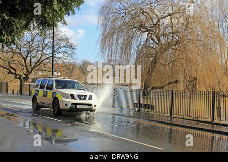 Cobham, Surrey, England, UK. 2nd February 2014. After the exceptional levels of rainfall across the UK, the River Mole has burst its banks in many places in Surrey. Here in Cobham, Mill Road is flooded with several inches of water from the adjacent river. A Surrey Police car sends a spray of water into the air as it passes through the flood. Credit:  Julia Gavin/Alamy Live News Stock Photo