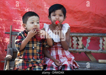 Two kids playing with balloons Bagan during the Ananda temple Festival Stock Photo