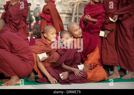 Monks in procession, waiting in a long line to collect alms during The Ananda Festival Bagan Myanmar Stock Photo