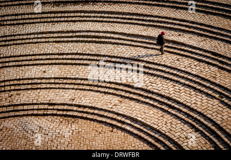 Lone person ascending the curved steps leading from El Djem Amphitheatre, Tunisia. Stock Photo
