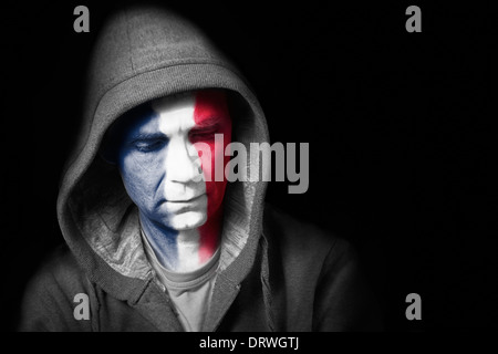 A sad expression on the face of a football fan with their face painted with the French flag. Stock Photo