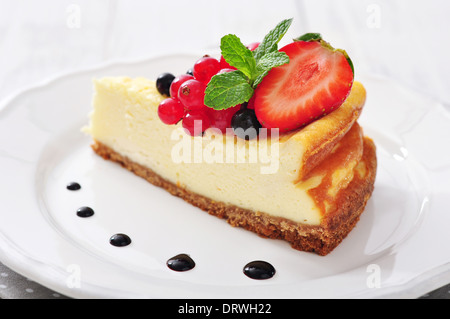 Cheesecake with fresh berries and mint on plate closeup Stock Photo