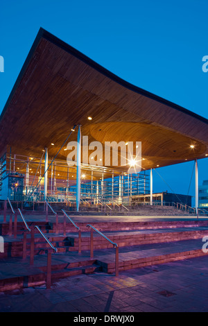 Welsh National Assembly building the Senedd Cardiff Bay Cardiff Wales at twilight and Millennium Centre in b/g Stock Photo