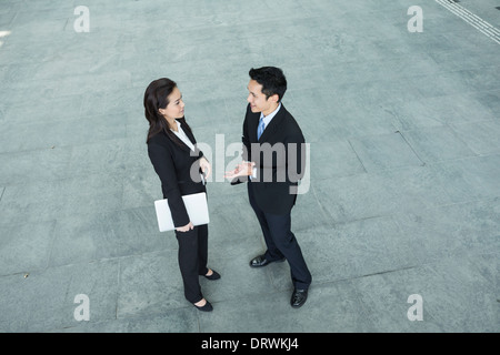 Above view of two Happy Chinese Business colleagues standing outside office & talking to each other. Stock Photo