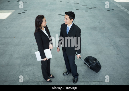 Above view of two Happy Chinese Business colleagues standing outside office & talking to each other. Stock Photo