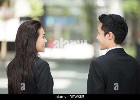 Happy Chinese Business colleagues outside the office talking to each other. Stock Photo