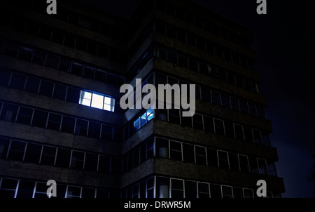 Office building at night with only one window lit Stock Photo