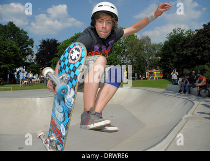 A young skateboarder jumps with his skateboard at an urban skateboard park. Stock Photo
