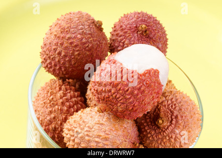 Close-up of some litchis (lychee) in a glass over a light green background. Stock Photo