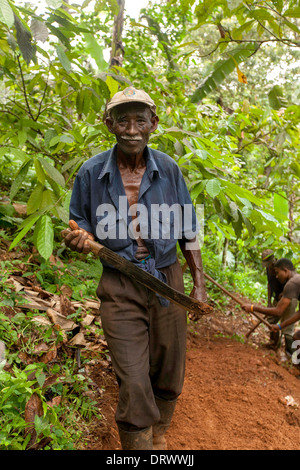 Old man working on an unmade road, Principe Island Stock Photo