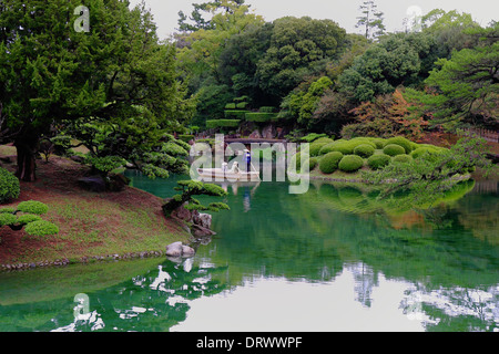 TAKAMATSU, JAPAN - OCTOBER 19: The tourists sail on boat across the Ritsurin  garden ponds, the most beautiful park of Japan  on Stock Photo