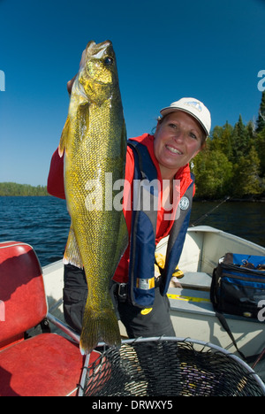 Woman angler holding the summer walleye she caught in Northern Ontario, Canada. Stock Photo