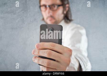 Businessman taking picture with mobile phone, selective focus on device and hand Stock Photo