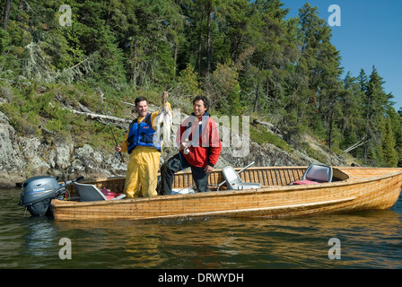Fishing buddies hold up their summer lake trout catch in a boat on a lake  in Northern Ontario Stock Photo - Alamy