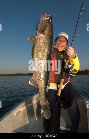 Woman angler holding the summer walleye she caught in Northern Ontario, Canada. Stock Photo