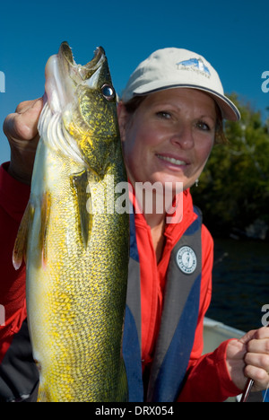 Woman angler holding the summer walleye she caught in Northern Ontario, Canada. Stock Photo