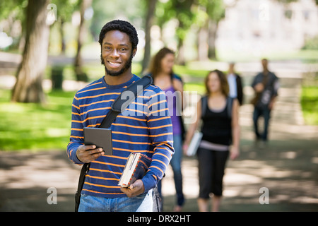 Happy Student Holding Digital Tablet On Campus Stock Photo