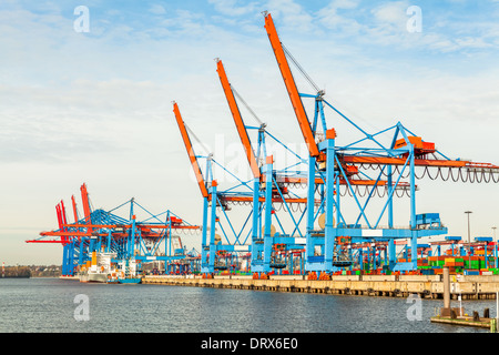 Deserted port terminal in a harbour for loading and offloading cargo ships and freight with rows of large industrial cranes to lift goods off the decks and from the holds Stock Photo