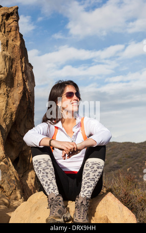 Hiker relaxes on rock formation near Skull Rock above the Temescal Ridge Trail, accessed by Temescal Gateway Park Stock Photo