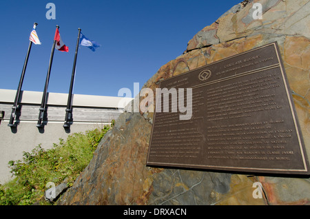 Canada, Newfoundland, L'Anse aux Meadows National Historic Site, Parks Canada. Visitor Center with flags and UNESCO marker. Stock Photo