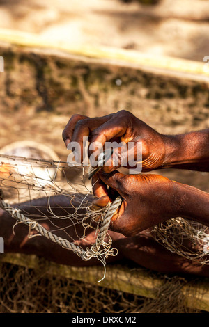 Fisherman repairing fishing net, Principe Island Stock Photo