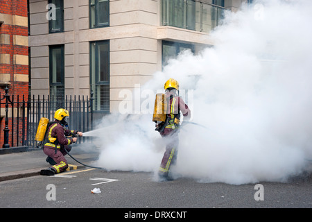 Firemen putting out a fire on a Van in a London Street Stock Photo