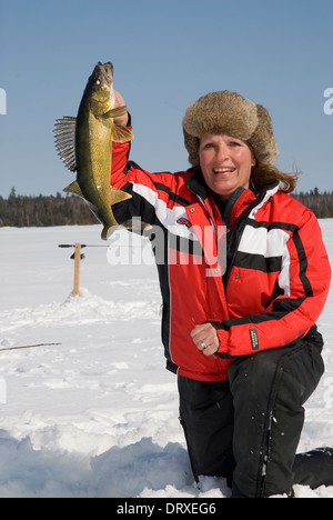 Woman holds up a winter walleye she caught ice fishing Stock Photo - Alamy