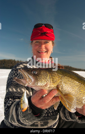 Woman holds up a winter walleye she caught ice fishing. Stock Photo