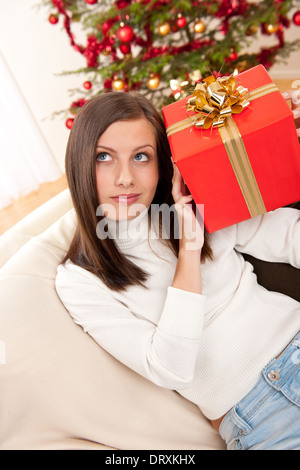 A young woman holding a Christmas present Stock Photo - Alamy