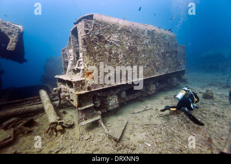 A scuba diver passes a coal tender on the wreck of the SS Thislegorm, Red Sea, Egypt Stock Photo