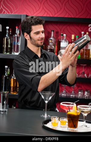 Young bartender make cocktail shaking drinks Stock Photo
