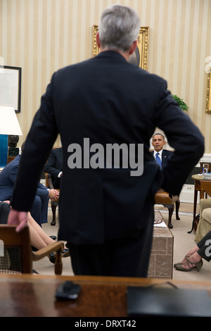 President Barack Obama is framed by the arm of Cody Keenan, Director of ...