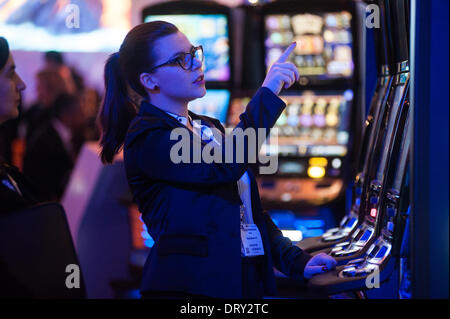 London, UK - 4 February 2014: a woman plays at slot machines at the ICE Totally Gaming 2014 show, the biggest event in the gaming industry. Credit:  Piero Cruciatti/Alamy Live News Stock Photo