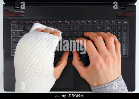 Working on a notebook with hand injury Stock Photo