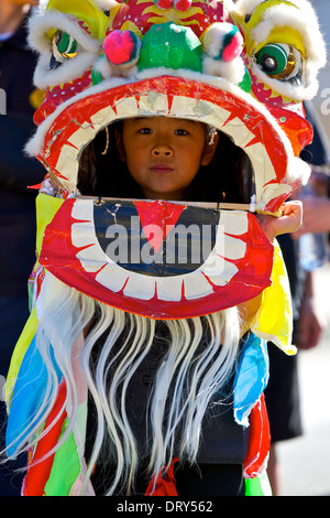 A Young Chinese Girl dressed in a Traditional Dragon Dance Costume, waits to perform in the Los Angeles Chinatown Parade. Stock Photo