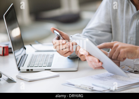 Men using wireless devices, cropped Stock Photo
