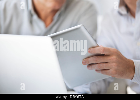 Men using digital tablet and laptop computer, cropped Stock Photo