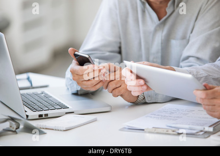 Men using wireless devices, cropped Stock Photo