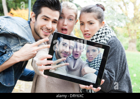 Friends photographing themselves with digital tablet outdoors Stock Photo