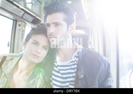 Couple together on train, woman resting her head on man's shoulder Stock Photo