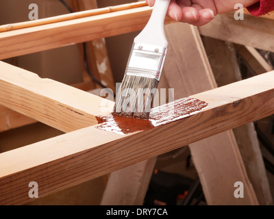applying protective primer on wooden rack Stock Photo