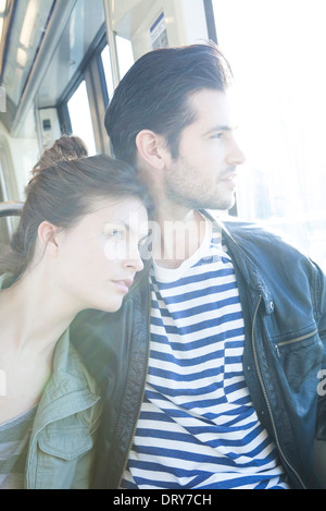 Couple riding train together, looking out window Stock Photo